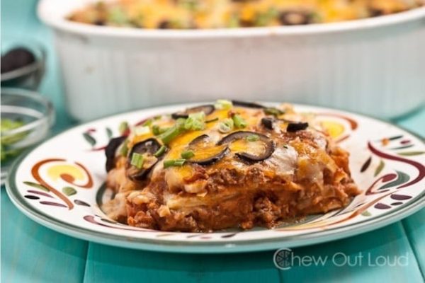 A plate of cheesy enchilada casserole on a table.
