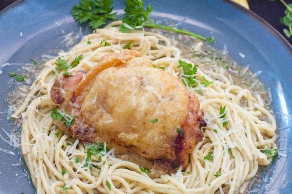 A plate of spaghetti with chicken and parsley, the perfect pasta dish for a comforting meal.