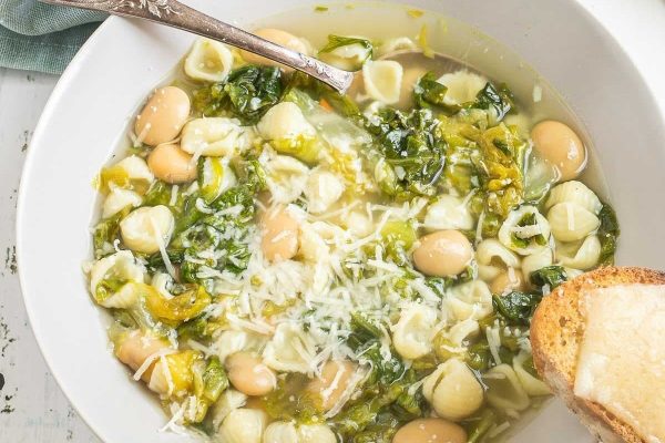 A simple and delicious bowl of pasta soup, made with a few ingredients and served with greens and bread.
