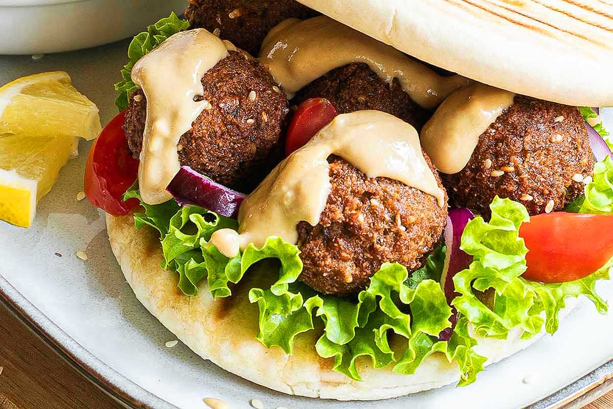 Gyro meatballs with tzatziki sauce on a plate.