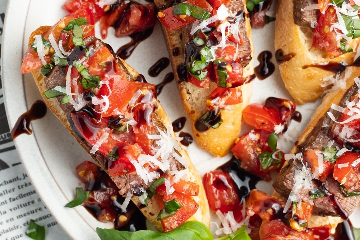A festive plate of bruschetta with tomatoes and basil, perfect for New Year's Eve appetizers.