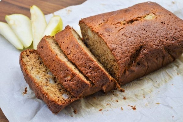 A slice of apple bread on a piece of paper.