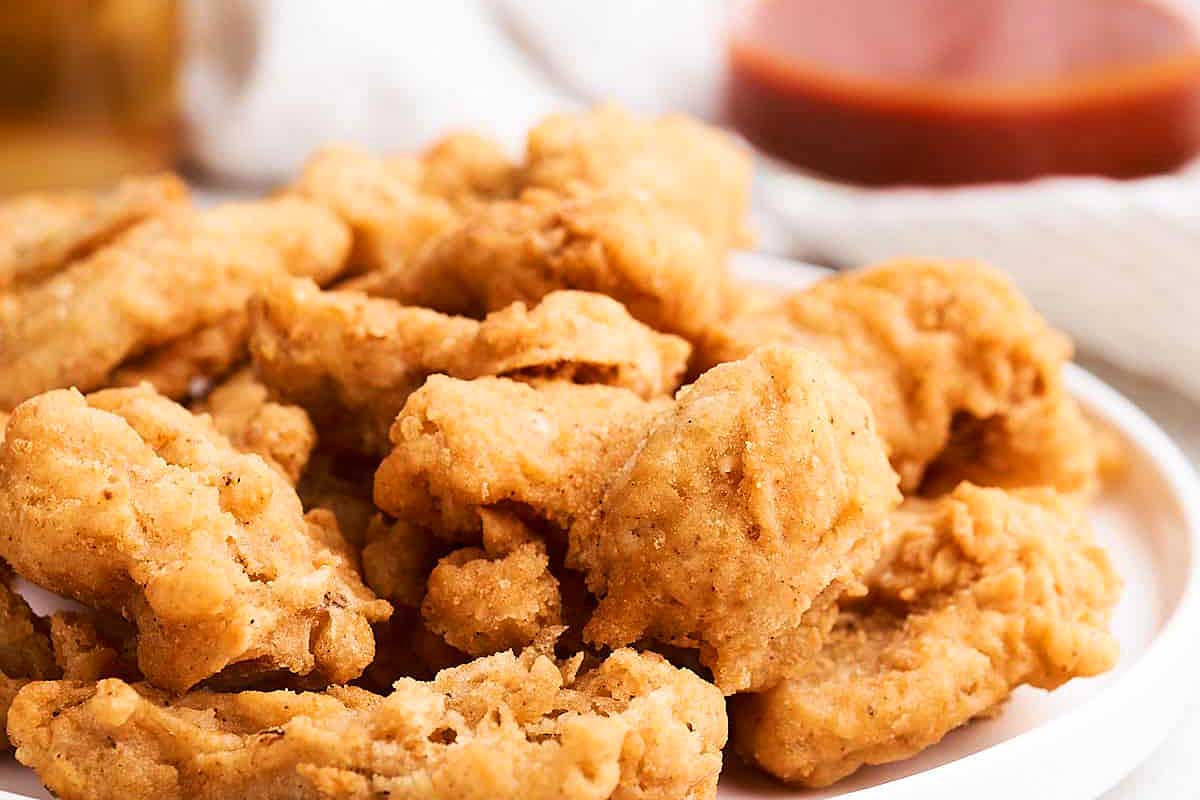 Pub-style fried chicken nuggets on a white plate.
