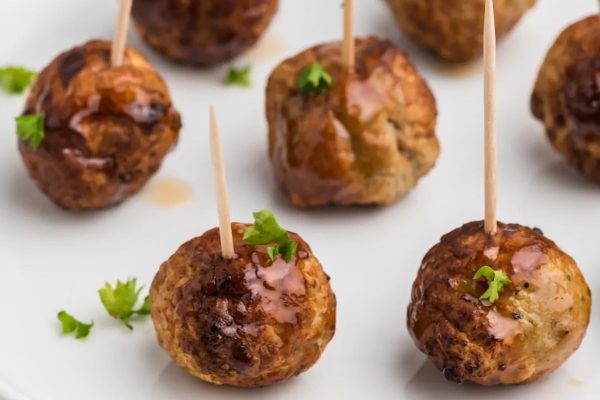 Meatballs with toothpicks on a plate.