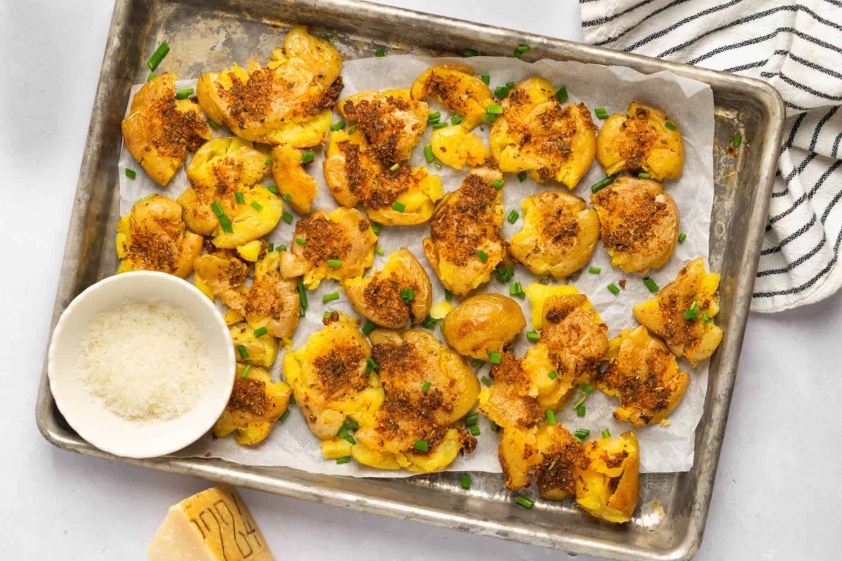 A sheet pan recipe for Thanksgiving featuring fried potatoes topped with parmesan cheese.