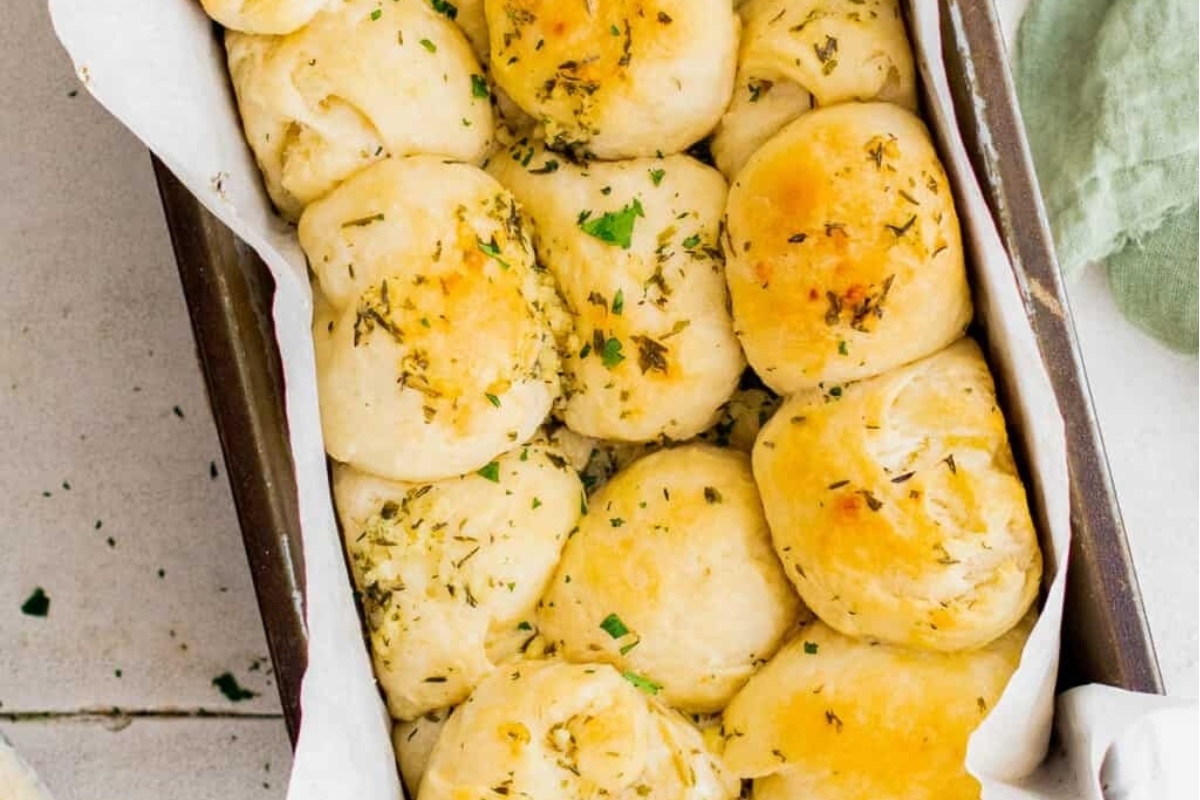 Bread rolls in a baking dish with herbs, perfect for your bread basket or as a delicious addition to your recipes.