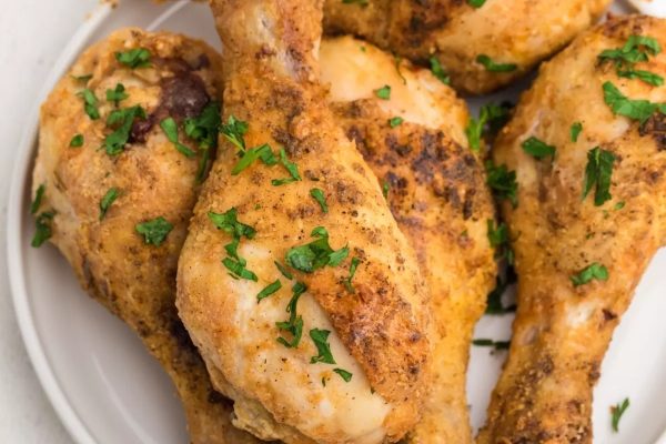 Roasted chicken legs on a white plate.
