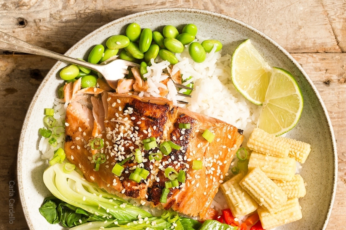 A white plate with salmon and vegetables on it, perfect for dinners.