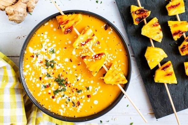 Grilled pineapple skewers in a bowl.