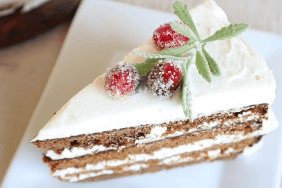 A festive Christmas cake adorned with cranberries and a tempting icing, elegantly displayed on a plate.