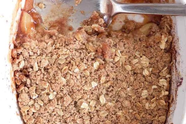 A scoop of oat crumble in a white baking dish.