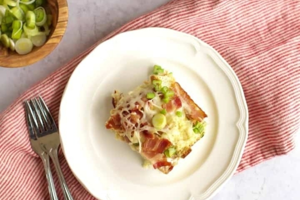 Christmas breakfast casserole on a white plate with a fork.