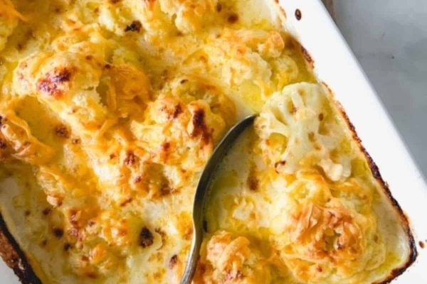 Cheesy cauliflower casserole in a white baking dish.