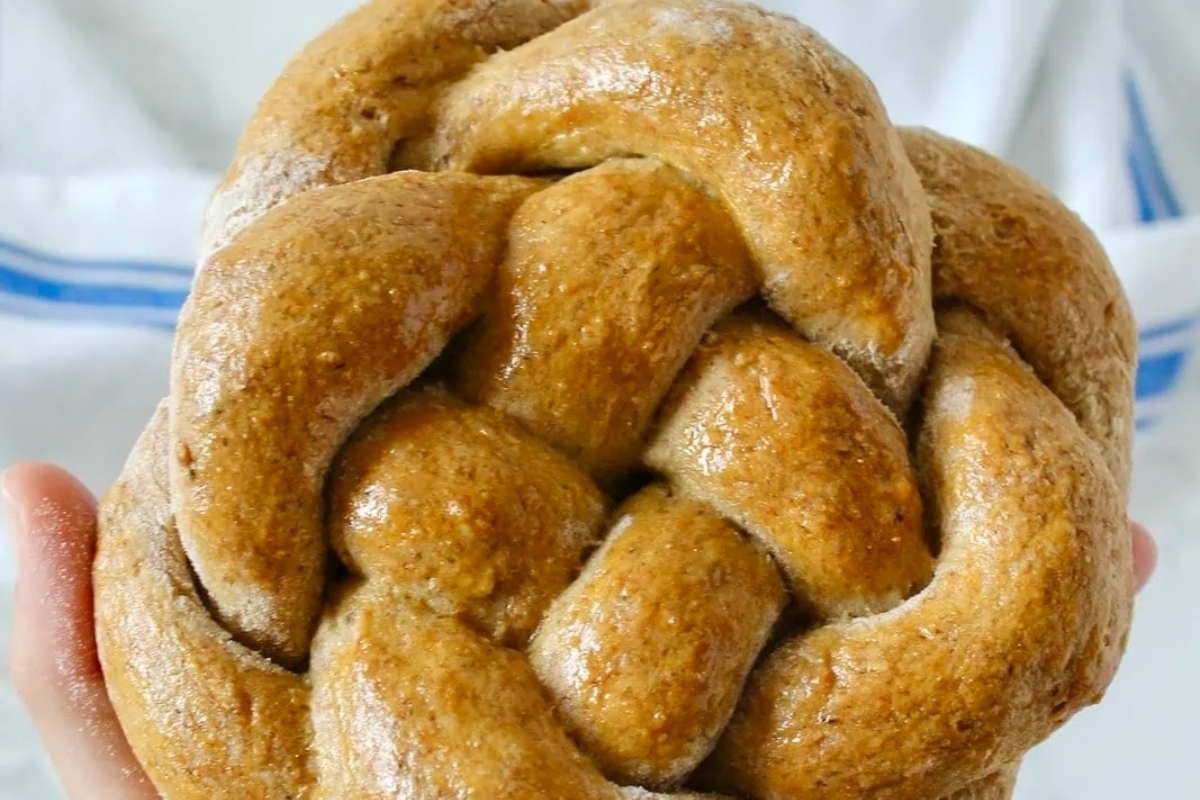 A person is holding an edible braided bread, perfect for Christmas gifts.