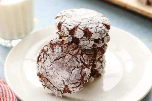 Christmas cookies, perfect for gifting, are beautifully displayed on a plate alongside a refreshing glass of milk.