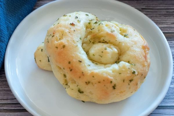 A white plate with a cheesy bread on it.