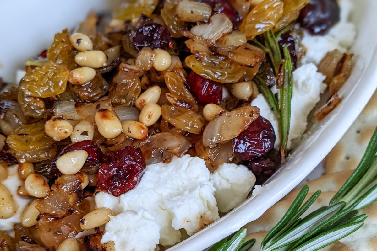 A festive white bowl filled with a delightful mix of cranberries, nuts, and crackers - perfect for New Year's Eve appetizers.