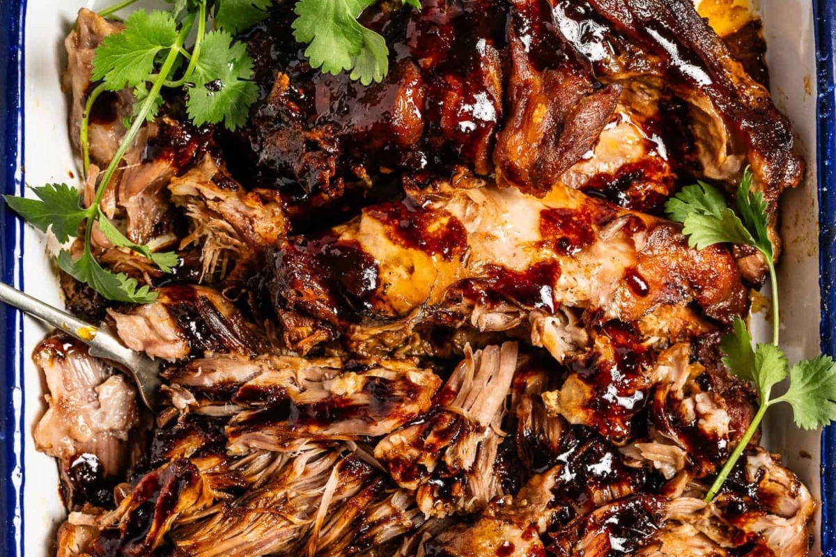 Pork tenderloin in a baking dish with sauce and cilantro, perfect for pork dinners.