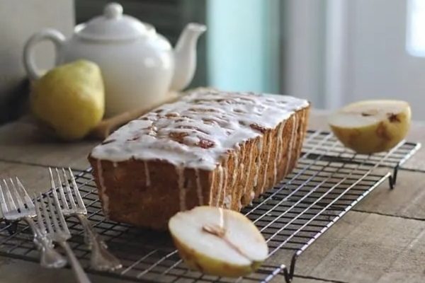 Pear bread with icing on a cooling rack.