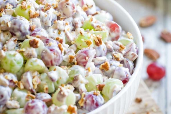 Grape salad with pecans in a white bowl perfect for potluck.