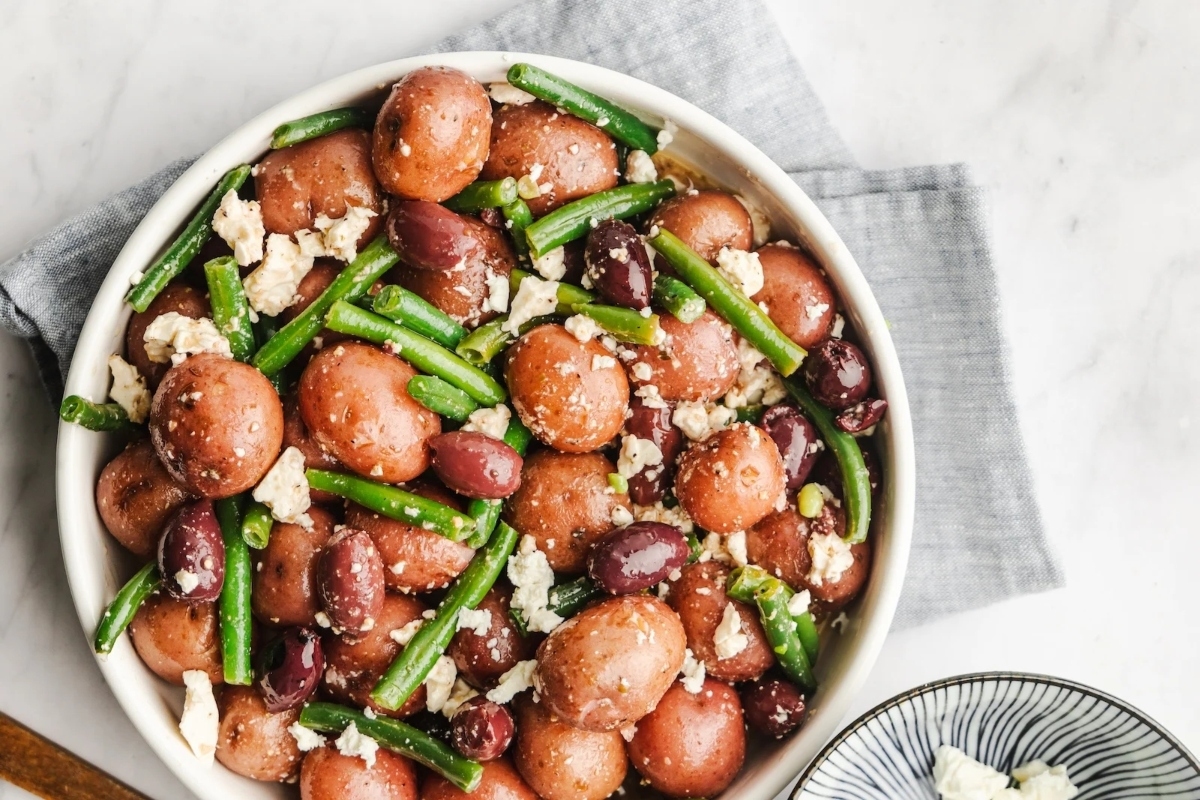 Potatoes and green beans in a white bowl.