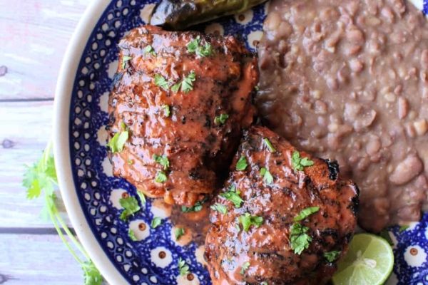 A plate with chicken and beans on it.