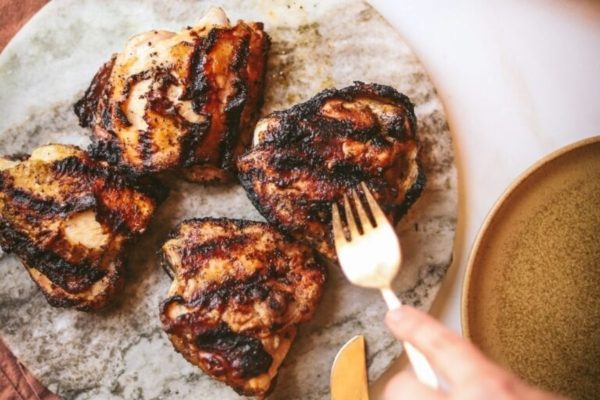 Grilled chicken on a plate with a fork.