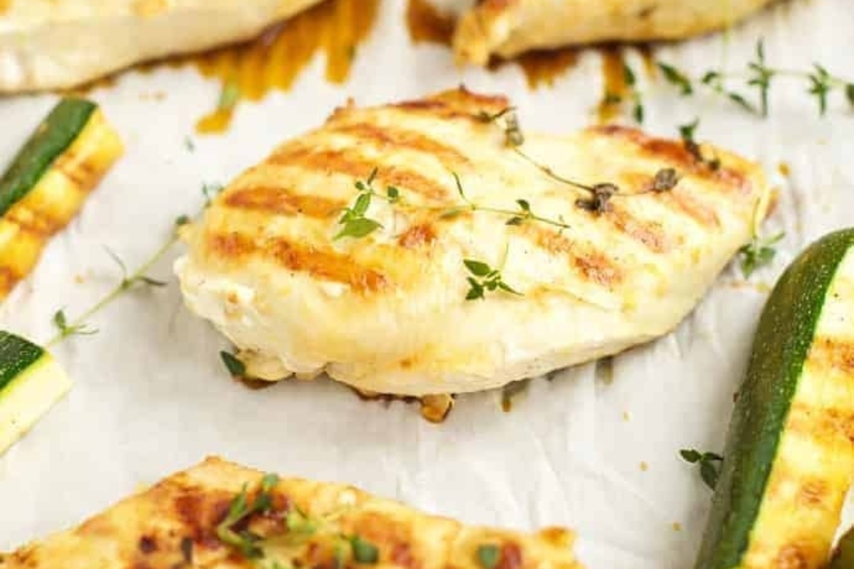 Grilled chicken and zucchini on a baking sheet.