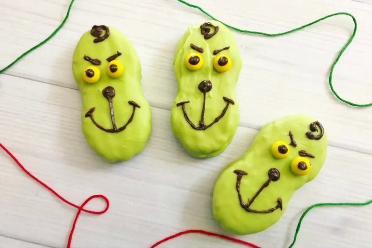 Three green cookies with smiley faces on them, perfect for a Grinch-themed party or to add a fun touch to your cookie recipes.