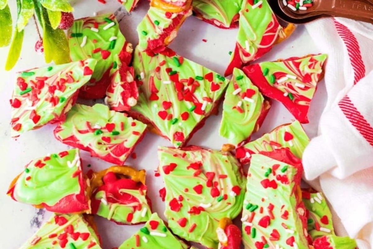 Festive Christmas bark topped with red and green sprinkles displayed on a white plate.