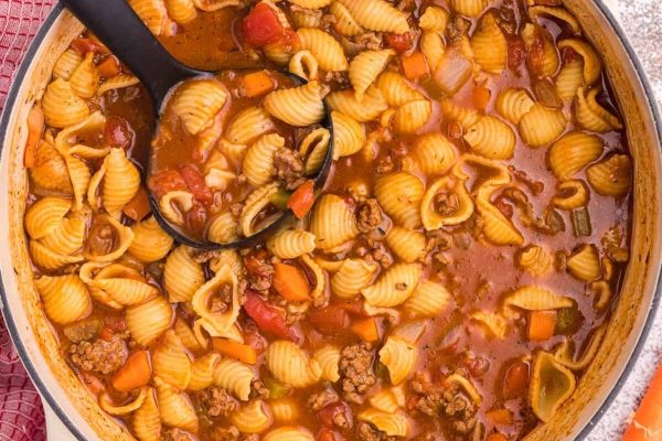 A pot of hamburger soup with meat and vegetables.