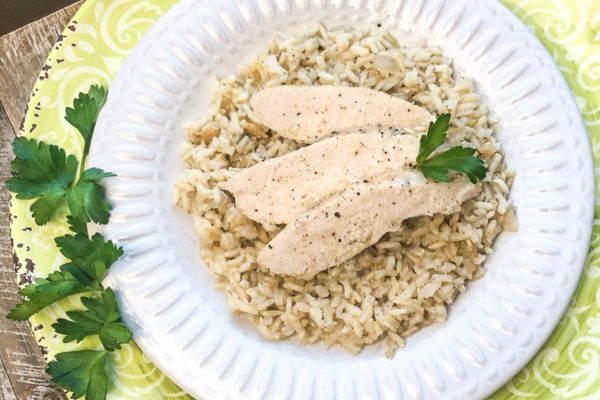 Chicken with rice and parsley on a plate.