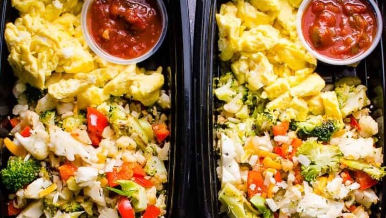 Two plastic containers with meal prep including vegetables and eggs for breakfast.