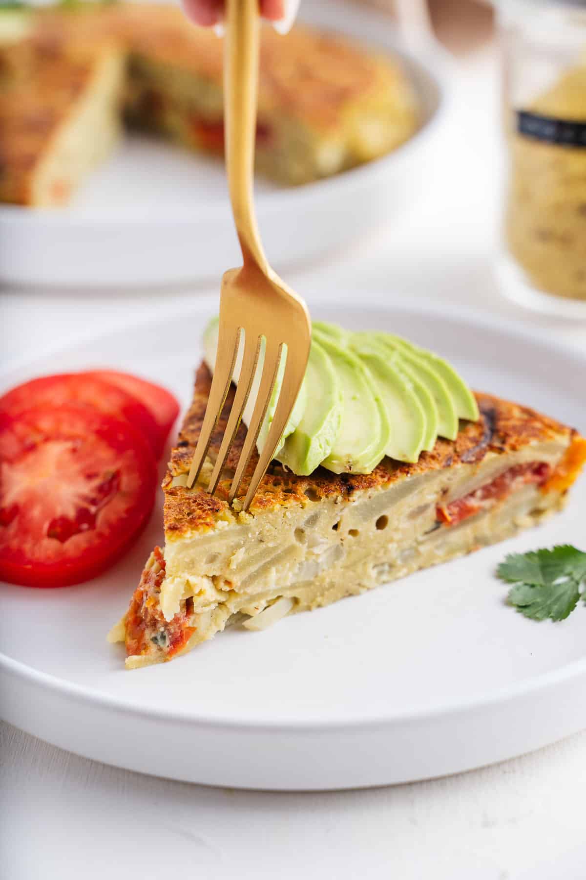 A slice of guacamole quesadilla on a plate with a fork.