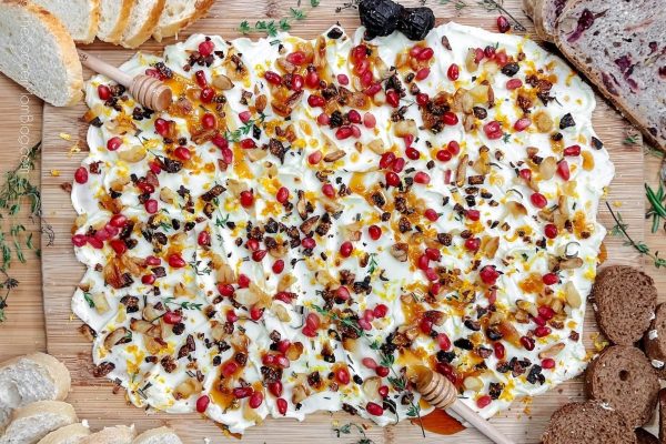 A Christmas-themed charcuterie board with a variety of breads and cheeses.
