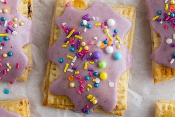 A tray of rainbow frosted graham crackers with sprinkles and icing.