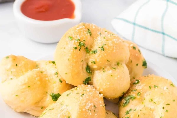 Cheesy garlic knots on a white plate.
