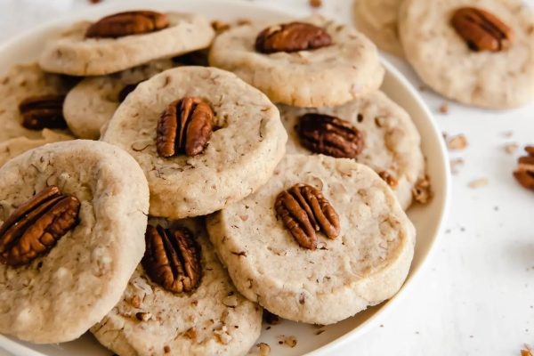 Pecan cookies in a bowl with pecans.