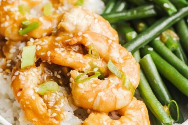 A bowl of rice with shrimp and green beans.