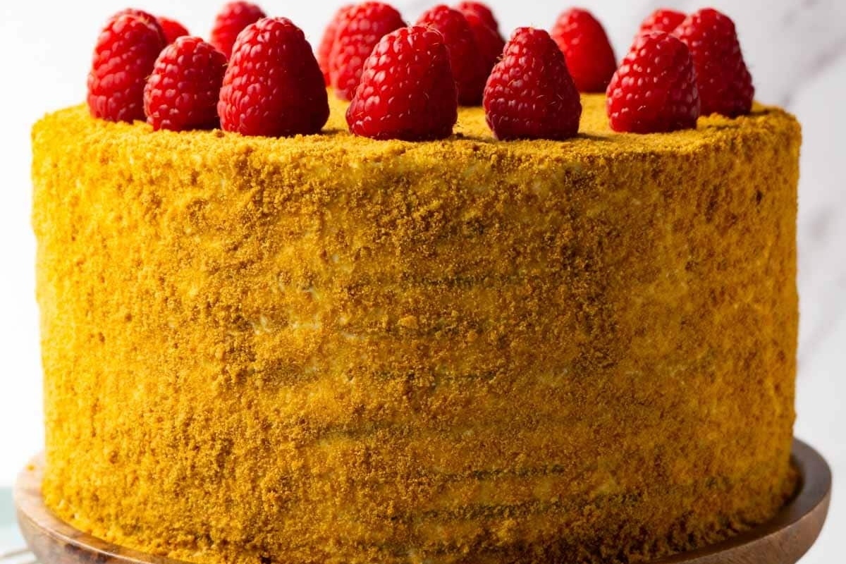 A festive Christmas cake with raspberries on top.