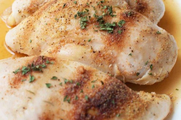 Two chicken breasts on a white plate.