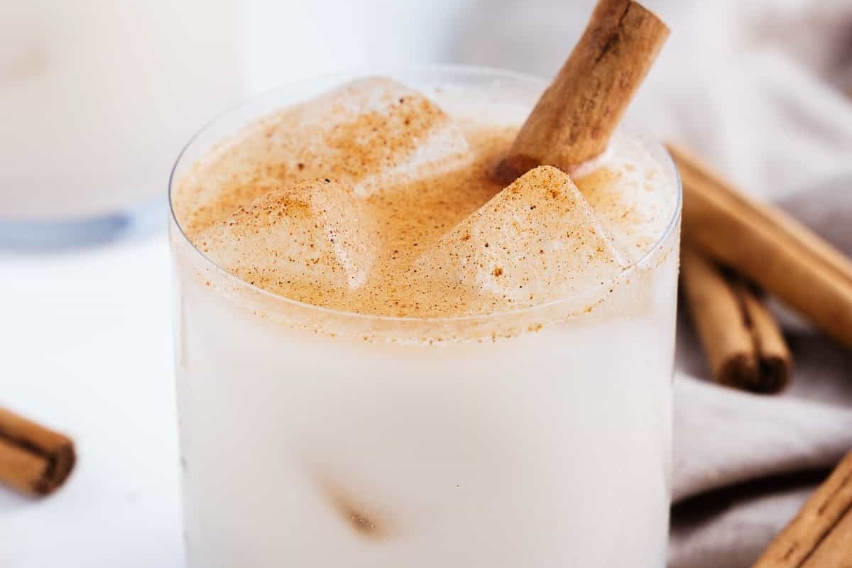 A refreshing glass of cinnamon iced tea garnished with cinnamon sticks.