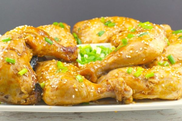 Baked chicken quarters on a plate.
