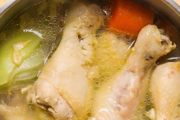 Boiled chicken legs with carrots.