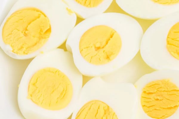 Breakfast with hard boiled eggs on a white plate.