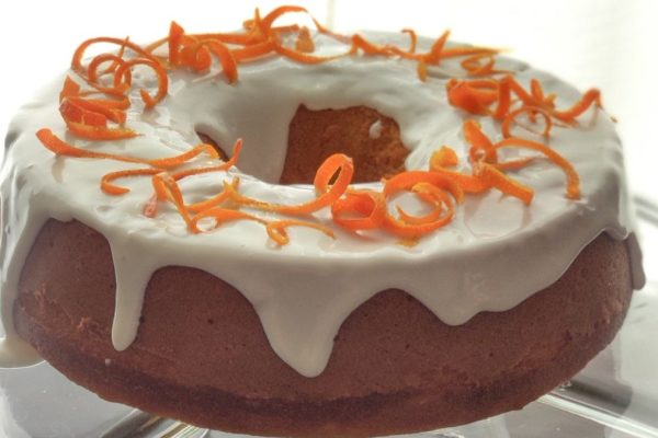 A bundt cake with orange icing on top.