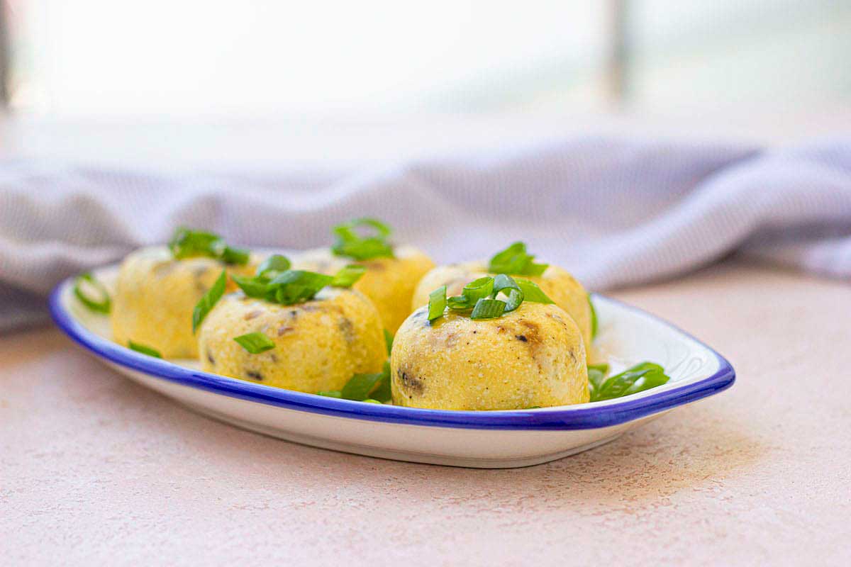 A white plate with a few egg balls on it.