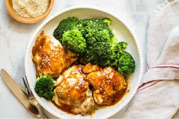 Chicken Teriyaki with broccoli and sesame seeds in a white bowl.