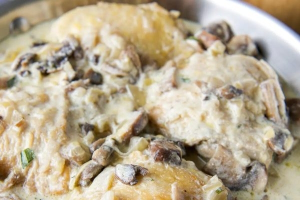 A bowl of mushrooms and potatoes in a sauce.