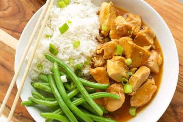 A white plate with chicken, rice and green beans.